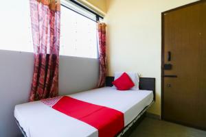 a small bedroom with a bed with a window at Flagship Shree Raksha Comforts in Devanhalli