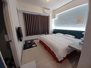 a bedroom with a large bed and a television at 111 Gukeng Homestay 