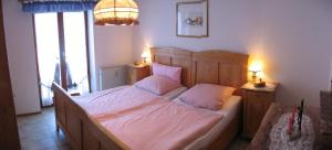 ein Schlafzimmer mit einem großen Bett mit rosa Kissen in der Unterkunft Haus Wendelweg in Unterwössen