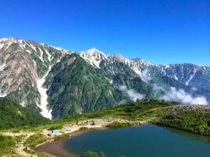 a view of a mountain range with a lake at Hakuba Onsen Ryokan Shirouma-so in Hakuba