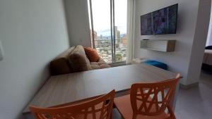 d'une table à manger et de chaises avec une grande fenêtre. dans l'établissement Apartaestudio San Martin, La Quinta, à Bogotá