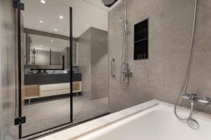 a bathroom with a shower and a bath tub at Somerset Taihu New City CBD Wuxi in Wuxi +26 photos