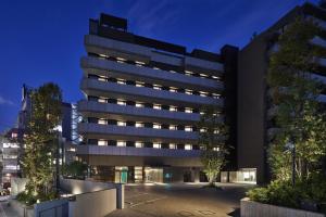 un bâtiment éclairé dans une ville la nuit dans l'établissement Prince Smart Inn Ebisu, à Tokyo