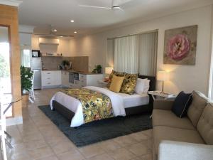 a large bedroom with a bed and a couch at SilverWaters Waterfront Accommodation Lake Macquarie in Morisset East