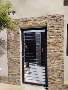 a door into a stone wall with a wooden deck at Temporarios Caseros SDE in Santiago del Estero