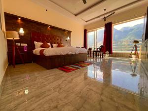 a bedroom with a large bed and a large window at Sitara Hotel & Resort, ! Most Awarded Property in Mussoorie in Mussoorie