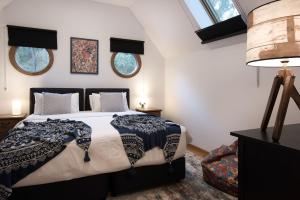 ein Schlafzimmer mit einem großen Bett und zwei Fenstern in der Unterkunft Abbotts Rest in Hepburn Springs