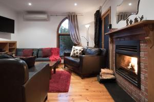 ein Wohnzimmer mit Sofas und einem Kamin in der Unterkunft Abbotts Rest in Hepburn Springs