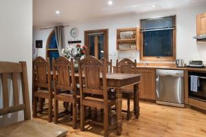 a kitchen with a wooden table and wooden chairs at Abbotts Rest in Hepburn Springs