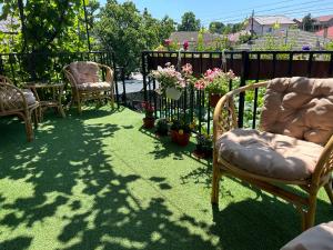 a yard with chairs and flowers and a fence at Vila MariCris in Tuzla