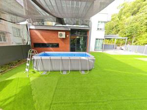 バトゥ・フェリンギにあるOcean 23 Batu Ferringhi Shamrock Beach with Swimming Pool 7 Bedroom 30paxの建物前の芝生のプール