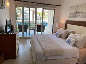 a bedroom with a bed with a television and a balcony at Palmeraie Terrenas beach apartamento in Las Terrenas +20 photos