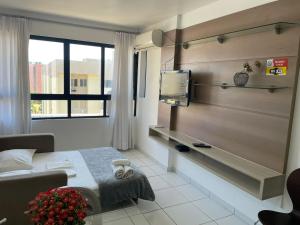 Habitación de hotel con cama y TV en Excelente Quarto e Sala na Ponta Verde, en Maceió