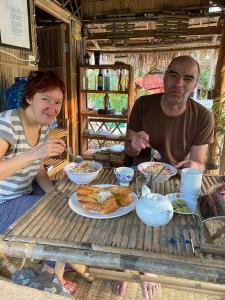 een man en een vrouw aan een tafel met eten bij Battambang Eco Stay in Phumĭ Ândong Pring