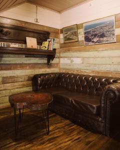 a leather couch in a room with a piano at Billinudgel Hotel in Billinudgel