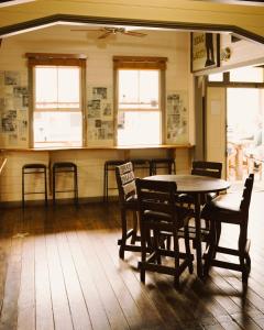 a dining room with a table and chairs and windows at Billinudgel Hotel in Billinudgel