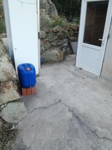 um barril azul sentado à frente de uma porta em Orman ev em Ayvacık