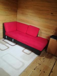 um sofá vermelho sentado no meio de uma sala em Orman ev em Ayvacık