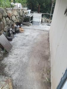 um quintal com uma parede de pedra e um quintal de terra em Orman ev em Ayvacık