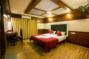 a bedroom with a bed with a red blanket at Angel Blue Houseboat Alapuzha in Alleppey