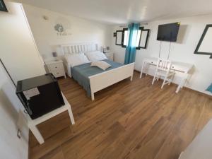 1 dormitorio con 1 cama, escritorio y TV en Ulivi di Cleo en Realmonte