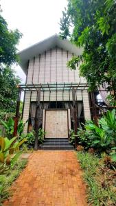 une maison avec une allée en briques menant à un garage dans l'établissement กมุทมาศ สวรรคโลก, à Ban Pa Muang (1)