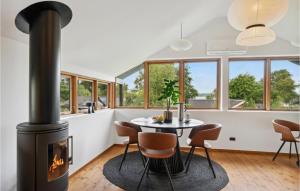 - un salon avec une cheminée, une table et des chaises dans l'établissement 1 Bedroom Lovely Home In Holbk, à Holbæk
