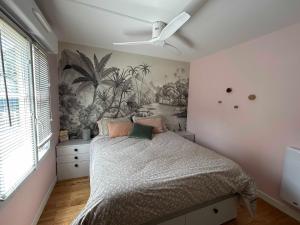 a bedroom with a bed with a mural of palm trees at T2 Cosy et calme en plein centre in Bordeaux