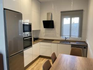 a kitchen with a wooden table and a refrigerator at Apartamento Casa Vivian in Merida