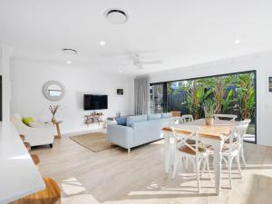 a living room with a table and chairs and a couch at Beach Pad on Nautilus in Kingscliff