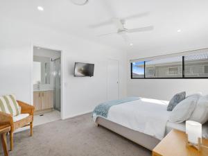 a white bedroom with a bed and a window at Beach Pad on Nautilus in Kingscliff +18 photos
