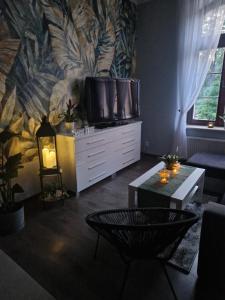 uma sala de estar com televisão em cima de uma cómoda em Apartament Blisko Natury em Olsztyn