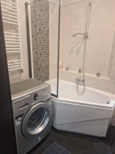 a bathroom with a washing machine and a bath tub at Apartament Blisko Natury in Olsztyn +26 photos