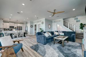 a living room with a blue couch and a kitchen at Beachfront - Hot Tub - BBQ - 14 Guests in Bolivar Peninsula