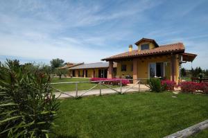 a house with a fence in front of a yard at Agriturismo dal Pastore in Follonica
