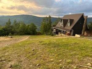 a large black house on top of a field at Mont Blanc Family Sporthotel in Vyshka