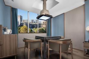 a dining room with a table and chairs and a window at Morning Hotel, Loudi Changqing Street Louxing Square in Loudi