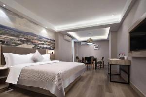 a hotel room with a bed and a dining room at Morning Hotel, Loudi Changqing Street Louxing Square in Loudi