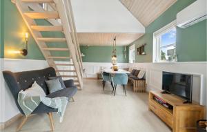 een woonkamer met een bank, een televisie en een tafel bij Nice Home In Fars With Kitchen in Farsø