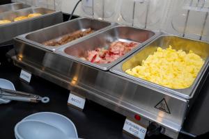 a buffet with some food in trays on a table at SPOT X Hotel Orlando Intl Dr by The Red Collection in Orlando