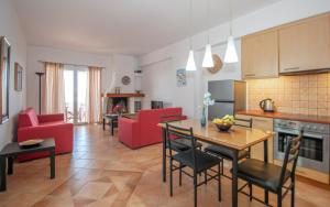 cocina y sala de estar con sillas rojas y mesa en Villa Zoi, en Méson Yerakaríon