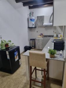 uma cozinha com um frigorífico preto e um balcão com uma cadeira em Gergla em Luján de Cuyo