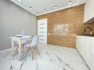 uma cozinha com uma mesa branca e piso em mármore em Апартаменты Freedom Greenline Сыганак Хан Шатыр em Taldykolʼ