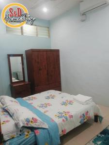 パダンセライにあるHomestay Taman Lagenda Padang Seraiのベッドルーム1室(花の飾られたベッド1台付)
