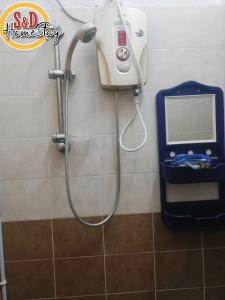 a shower in a bathroom with a soap dispenser at Homestay Taman Lagenda Padang Serai in Padang Serai