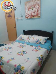 Un dormitorio con una cama con flores. en Homestay Taman Lagenda Padang Serai, en Padang Serai