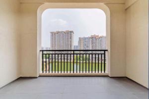 an empty room with a balcony with a view of buildings at Ramada By Wyndham Huizhou South in Huizhou