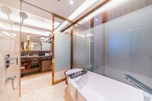 a bathroom with a tub and a sink at Ramada By Wyndham Huizhou South in Huizhou +26 photos
