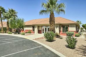 a building with a palm tree in front of a parking lot at Mesquite Vacation Rental Condo with Resort Amenities in Mesquite