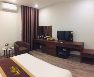 a hotel room with a bed and a television and a desk at Minh Thanh Homes - Hà Đông,Hà Nội in Hà Ðông